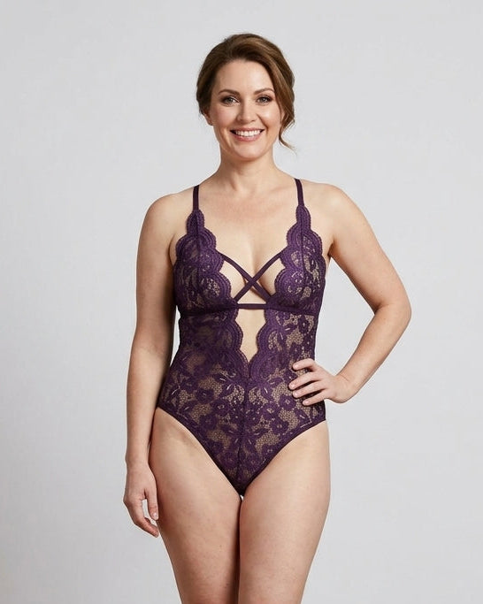 Woman wearing a purple lace lingerie set against a plain background