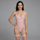 Woman wearing a pink lace lingerie set on a gray background